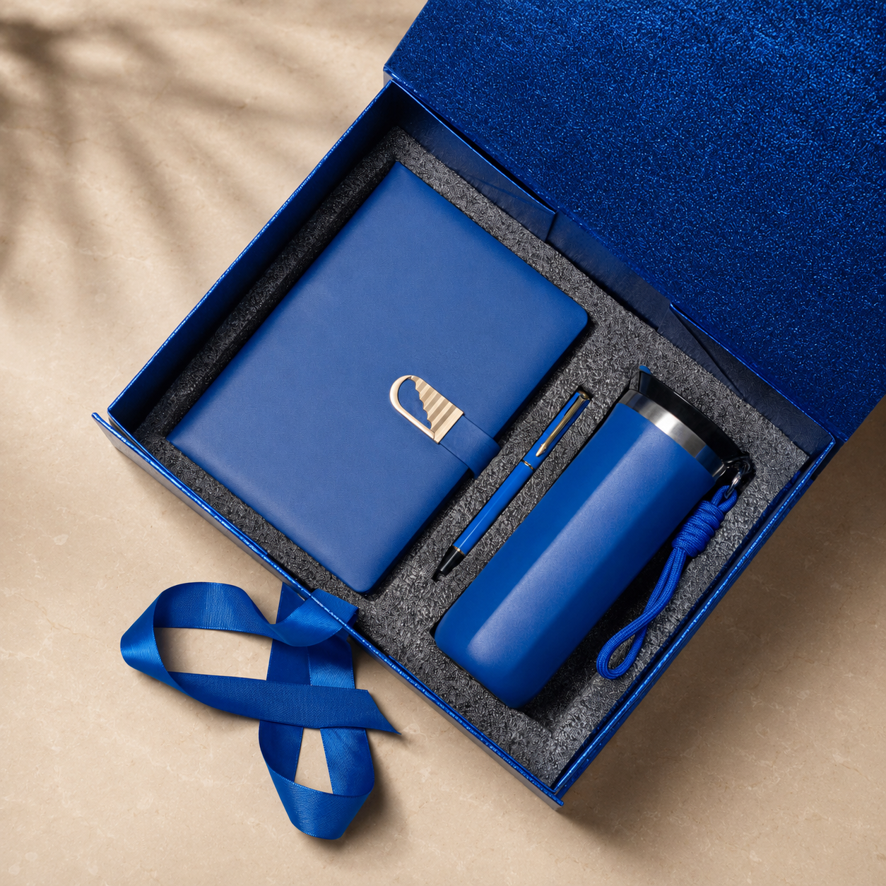 Notebook, pen and tumbler arranged in a gift box