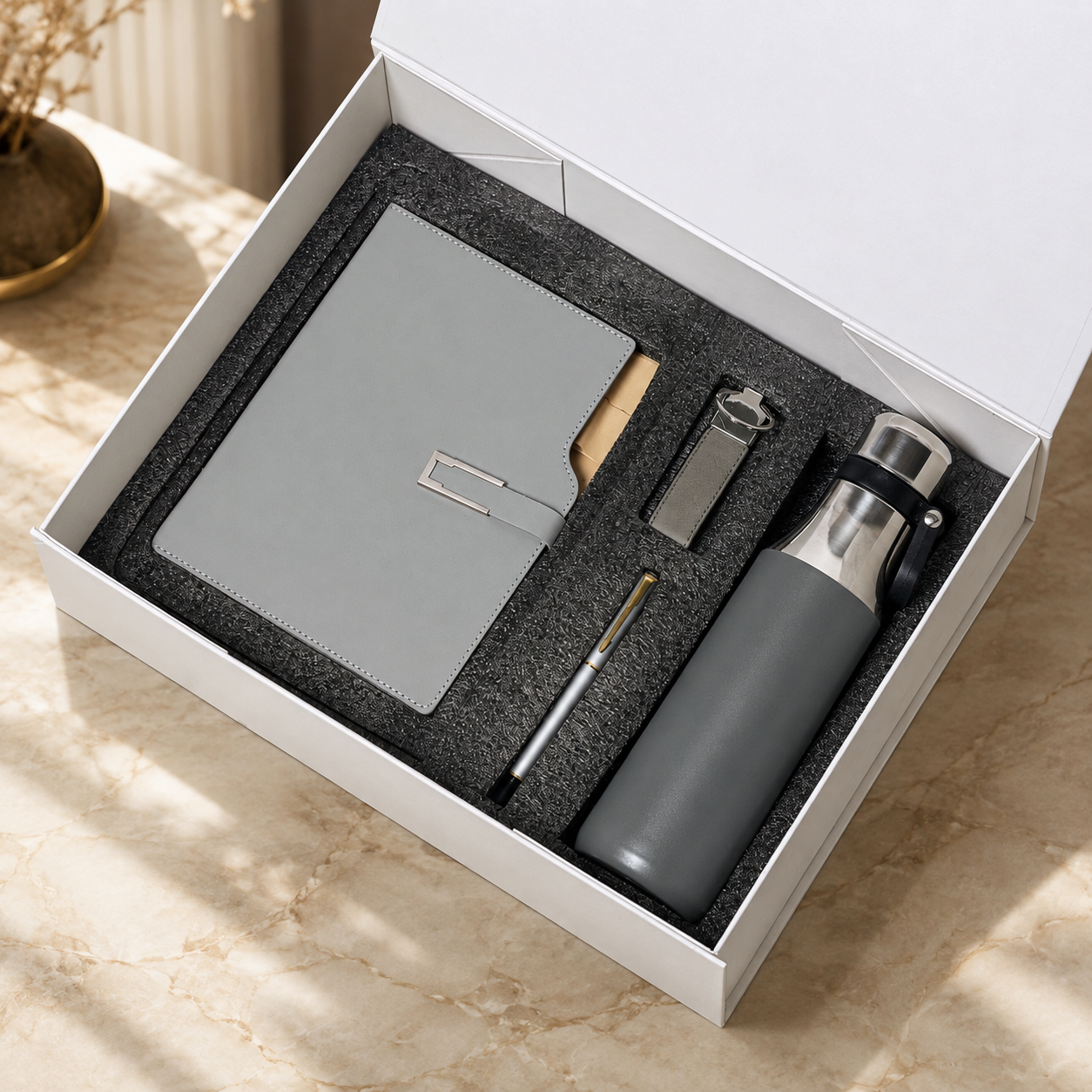 Notebook, pen and flask in a presentation box
