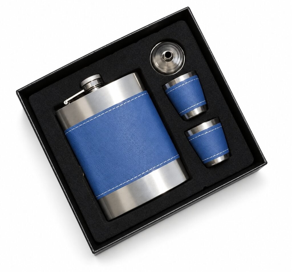One silver-tone hip flask with blue textured wrap and white stitching, two matching blue-wrapped small cups, and a funnel in a black presentation box on a white background