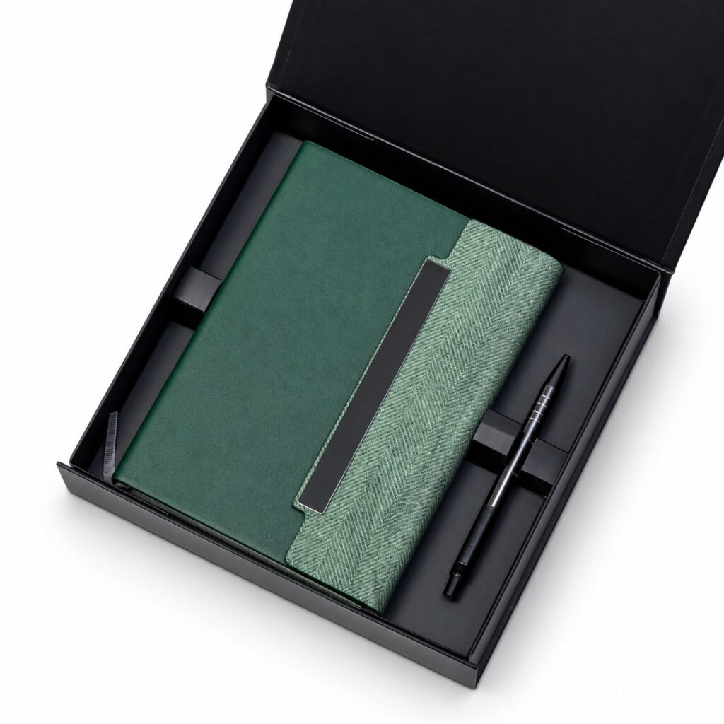 Green E113 notebook with textured flap and rectangular plate, black pen and presentation box on white