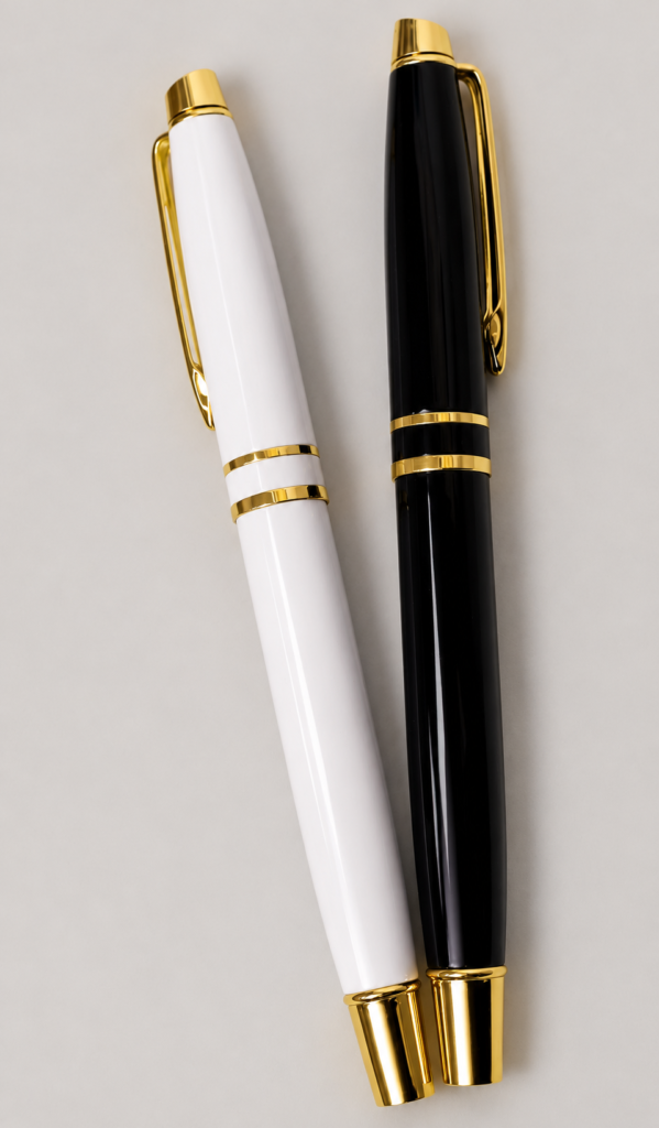 Black and white executive pens with gold clips and double gold bands on a neutral studio background