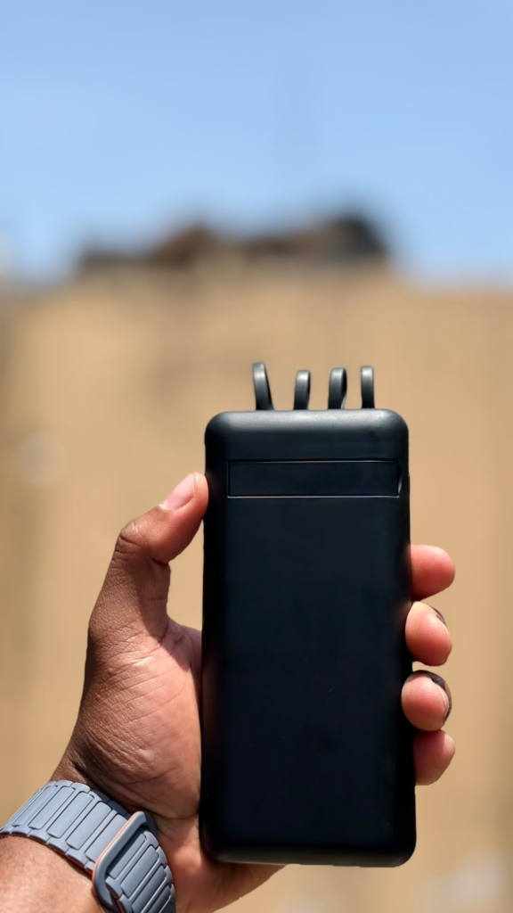 Black 10,000mAh power bank with built-in charging cables and display, front view